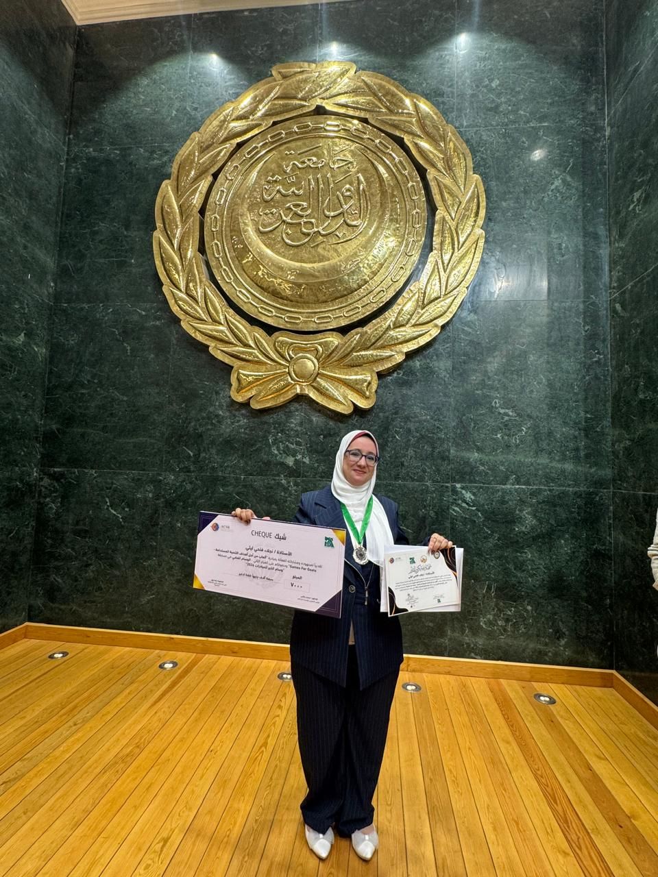 Naglaa at award ceremony 2 Una mujer mostrando con orgullo su premio y su cheque